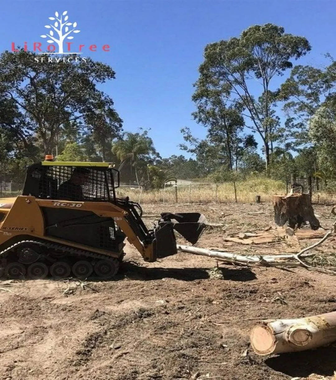 Loader clearing felled timber on a block