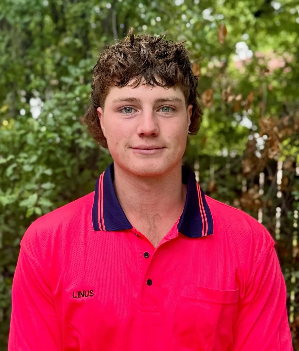 Linus, owner of LiRo Tree Services, in the pink LiRo work shirt